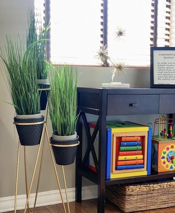 Children's play corner with toys and greenery, supporting child and family counseling at the office.