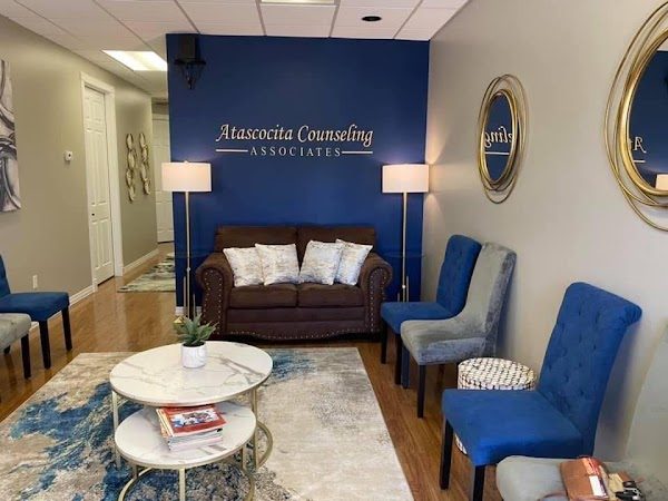 Waiting room at Atascocita Counseling Associates with the branded blue accent wall, loveseat, and accent chairs.