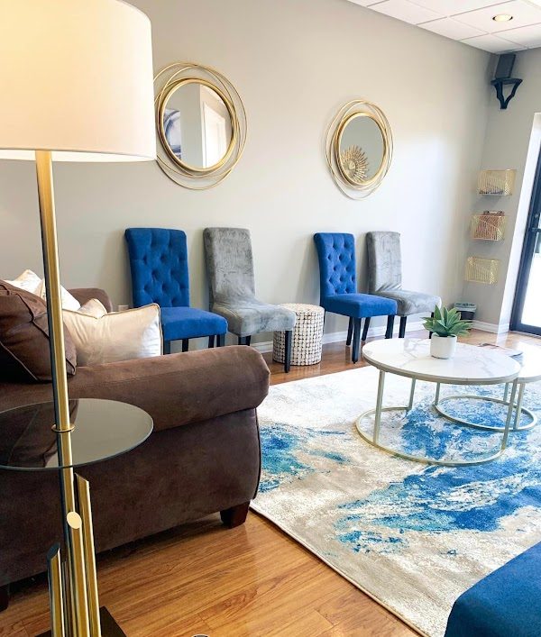 Comfortable waiting area seating with blue and gray accent chairs and a coffee table in the Humble counseling office.