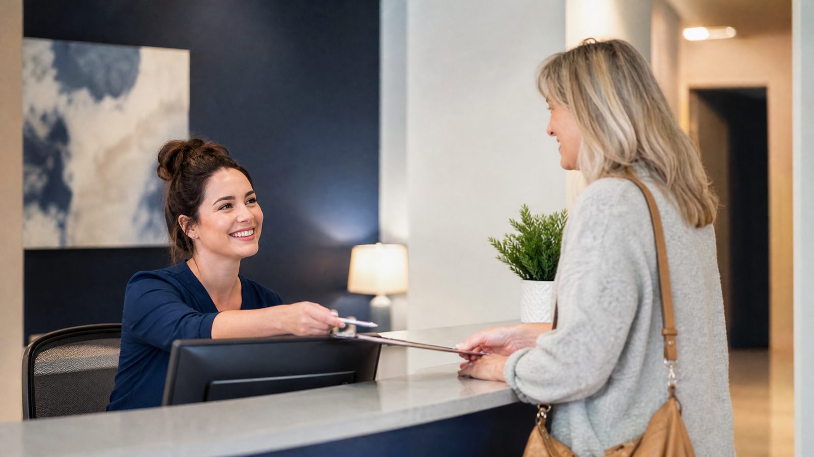 A friendly team member welcoming a new client at the Atascocita Counseling Associates front desk in Humble, TX.